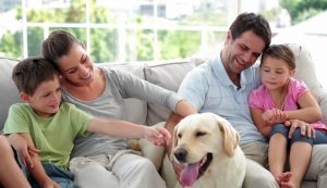 family petting a happy dog